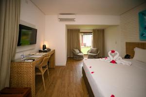 a hotel room with a bed and a desk with a computer at Grand Oca Maragogi All Inclusive Resort in Maragogi