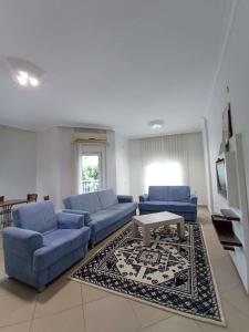 a living room with blue couches and a coffee table at begonvil evleri in Antalya