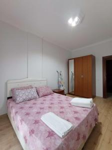 - une chambre avec un grand lit et une couverture rose dans l'établissement begonvil evleri, à Antalya
