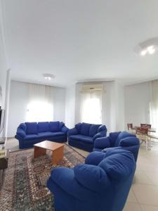 a living room with blue couches and a coffee table at begonvil evleri in Antalya