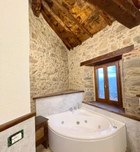 Cette chambre dispose d'une baignoire et d'une fenêtre. dans l'établissement ISA-Rooms with private bathroom in a villa with fenced garden surrounded by greenery in the Garfagnana area, shared kitchen, shared hydromassage tub and sauna, à Sillico