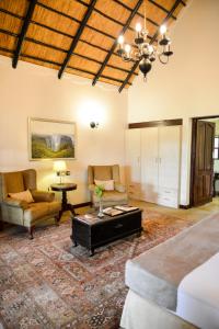 a bedroom with a bed and a couch and a table at Ursula's Homestead in Victoria Falls