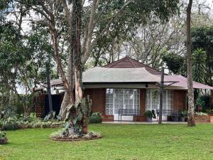 a small house with a tree in the yard at Zamani za kale in Kabuku