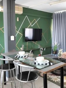 uma sala de jantar com uma parede verde e uma mesa com cadeiras em @Derricks Luxury Apartments 2 em Joanesburgo