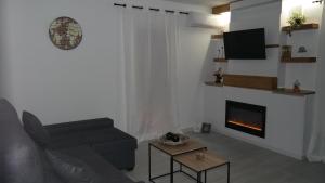 - un salon avec un canapé et une cheminée dans l'établissement GEINTUR TOLEDO MARIBEL HERITAGE, à Tolède