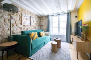 a living room with a green couch and a tv at 3p.cosy flat#6pers#heart of Le Marais in Paris