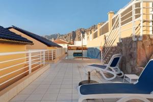 a balcony of a house with chairs and a fence at Great Sunset Views Los Gigantes in Acantilado de los Gigantes
