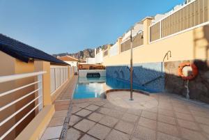 a swimming pool in the middle of a house at Great Sunset Views Los Gigantes in Acantilado de los Gigantes