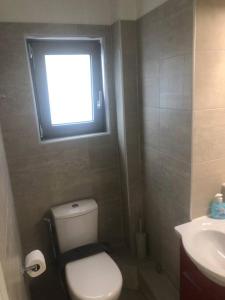 ein kleines Bad mit einem WC und einem Fenster in der Unterkunft Tsakalof 10 Central Apartment by SuperHost Hub in Athen