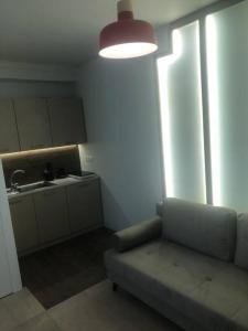 ein Wohnzimmer mit einem Sofa und einer Küche in der Unterkunft Tsakalof 10 Central Apartment by SuperHost Hub in Athen