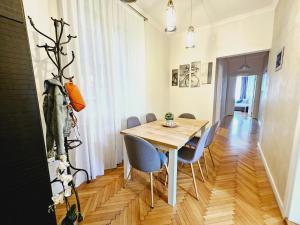 comedor con mesa de madera y sillas en Urban Downtown Apartment en Belgrado