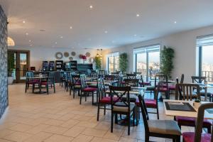 a dining room with tables and chairs and windows at Plaza Regency Hotels in Sliema