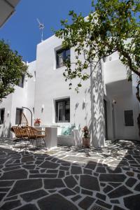 a patio with two chairs in front of a white building at Juliano luxury apartments, port of Naxos in Naxos Chora