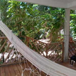 a hammock on the deck of a house at Casa da Andrea Imbassai in Imbassai