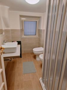 カターニアにあるCapuana Houseのバスルーム(トイレ、洗面台付)、窓が備わります。