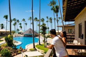 um homem e uma mulher ao lado de uma piscina num resort em Grand Oca Maragogi All Inclusive Resort em Maragogi