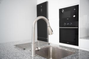 eine Küchenspüle mit Wasserhahn und Fernseher in der Unterkunft Isle Home By CanariasGetaway in Guanarteme + 47 Fotos