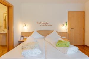 Una cama blanca con dos almohadas encima. en Stampferhof en Weissensee