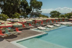 a pool with lounge chairs and umbrellas next to a resort at Dreams Calvia Mallorca in Magaluf