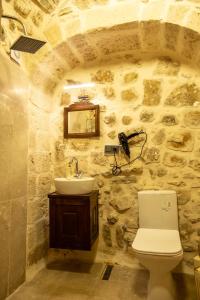 a stone bathroom with a toilet and a sink at ELYANS KONAĞI in Mardin