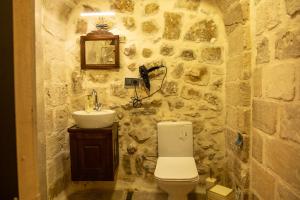 een stenen badkamer met een toilet en een wastafel bij ELYANS KONAĞI in Mardin