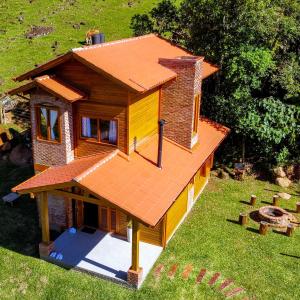 ein kleines Haus mit einem Dach auf einem Hof in der Unterkunft Chalé Vale das Pedras in Praia Grande