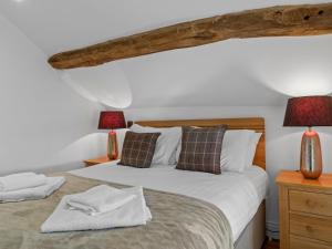 ein Schlafzimmer mit einem Bett und zwei Lampen an Tischen in der Unterkunft Pass the Keys 3 bed Cottage Above Beautiful Country Pub in Baycliff