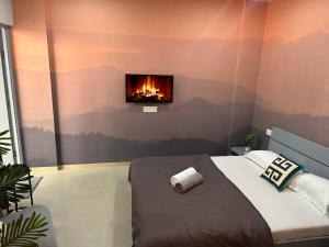 a bedroom with a bed with a fireplace on the wall at The Good Vibes Studio : AC, WiFi, Smart Tv in Pune