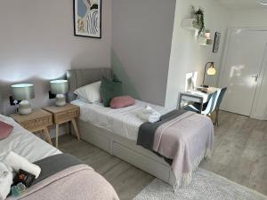 1 Schlafzimmer mit 2 Betten und einem Tisch mit einem Stuhl in der Unterkunft ASPIRE HOLIDAY HOMES in Bournemouth