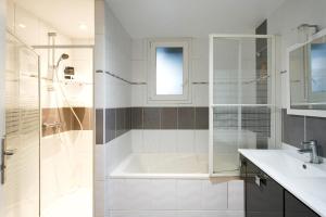 ein Badezimmer mit Badewanne, Waschbecken und Dusche in der Unterkunft Maison 3 chambres jardin 2km plage in Boucau + 18 Fotos