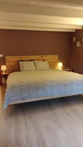 a bed with a wooden headboard in a bedroom at Gite : Le vi colombage de Petites-Tailles in Vielsalm