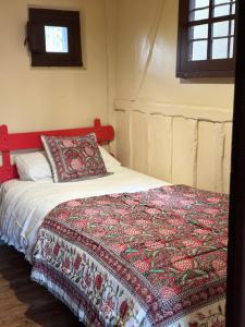 a bedroom with a bed with a red headboard at Exclusiva casa rural con jardín in Madriguera