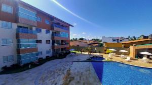 ein Schwimmbad vor einem Gebäude in der Unterkunft Porto Cayman Residence - Melhor trecho da Praia de Tamandaré in Tamandaré