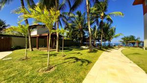ein Gehweg vor einem Haus mit Palmen in der Unterkunft Porto Cayman Residence - Melhor trecho da Praia de Tamandaré in Tamandaré