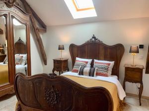 a bedroom with a large wooden bed with pillows at L'appartement du Pont de Cause in Saint-Cybranet