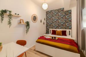 ein kleines Schlafzimmer mit einem Bett und einem Wandbild in der Unterkunft Long Stays Heaven - Comfortable & Spacious Apartments in Baneasa in Bukarest