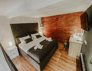 a bedroom with a large bed and a brick wall at Luxury Duplex Studios - City Center in Tbilisi City