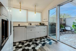 eine Küche mit weißen Schränken und einer Glasschiebetür in der Unterkunft Long Stays Heaven - Comfortable & Spacious Apartments in Baneasa in Bukarest