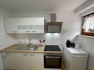 una piccola cucina con armadi bianchi e lavandino di Göttinger Betten a Gottinga