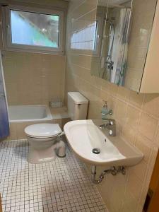 un bagno con lavandino, WC e finestra di Göttinger Betten a Gottinga