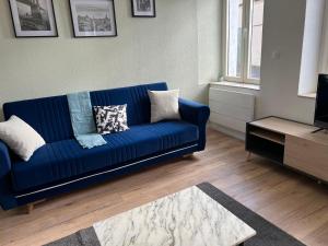 een woonkamer met een blauwe bank en een tafel bij Actipole 1 Metz Un Séjour à Part in Metz