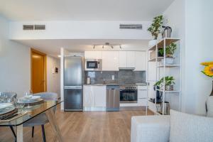 uma cozinha e sala de estar com uma mesa e um frigorífico em NIDO 380G em Roses