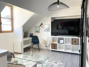Televízia a/alebo spoločenská miestnosť v ubytovaní Magnifique logement au pied du Château