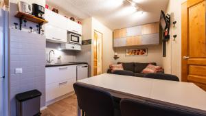 a kitchen and a living room with a table and chairs at Grande Neige 44 - Appt renove 4 pers in Morillon +2 photos