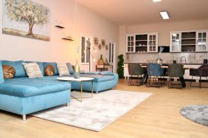 ein Wohnzimmer mit einem blauen Sofa und einem Tisch in der Unterkunft Herman Apartment Cisnadie in Cisnădie