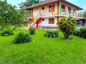 a house with a green lawn in front of it at Hostal Finca Villa Maria in Filandia