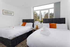 - 2 lits dans une chambre avec des oreillers blancs et orange dans l'établissement Flatzy - 16 Guests 4 En-suite Central Apartment A, à Liverpool