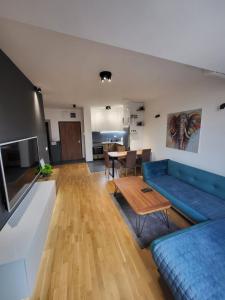 een woonkamer met een blauwe bank en een tafel bij 2 bedroom apartment in Skopje in Skopje