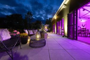 un patio con iluminación púrpura, mesa y sillas en The Club at Goffs, 