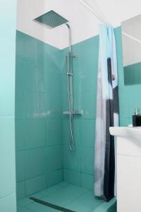 ein Bad mit einer Dusche und blauen Fliesen in der Unterkunft Herman Apartment Cisnadie in Cisnădie